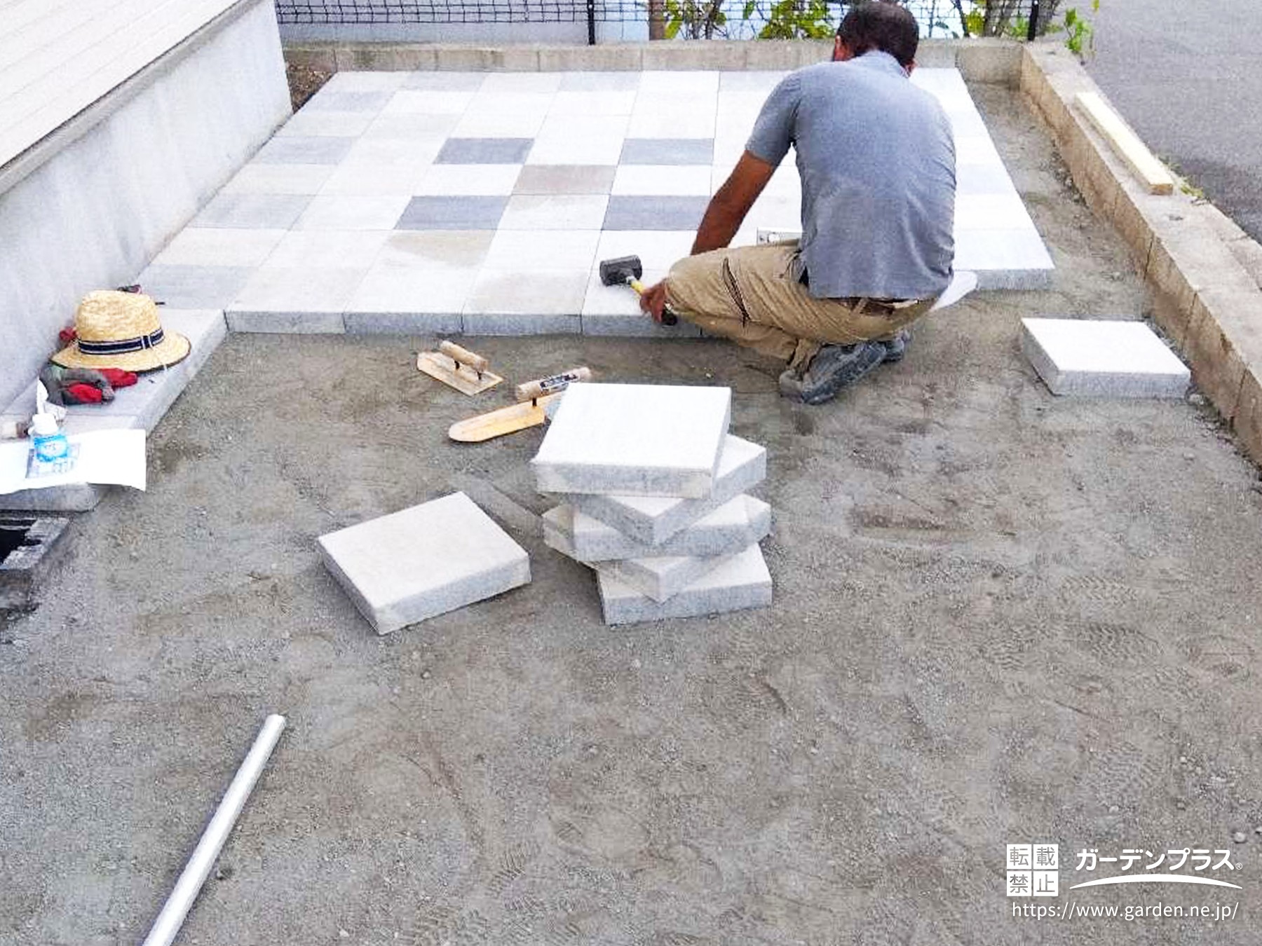 コンクリート平板を職人が丁寧に敷設している様子