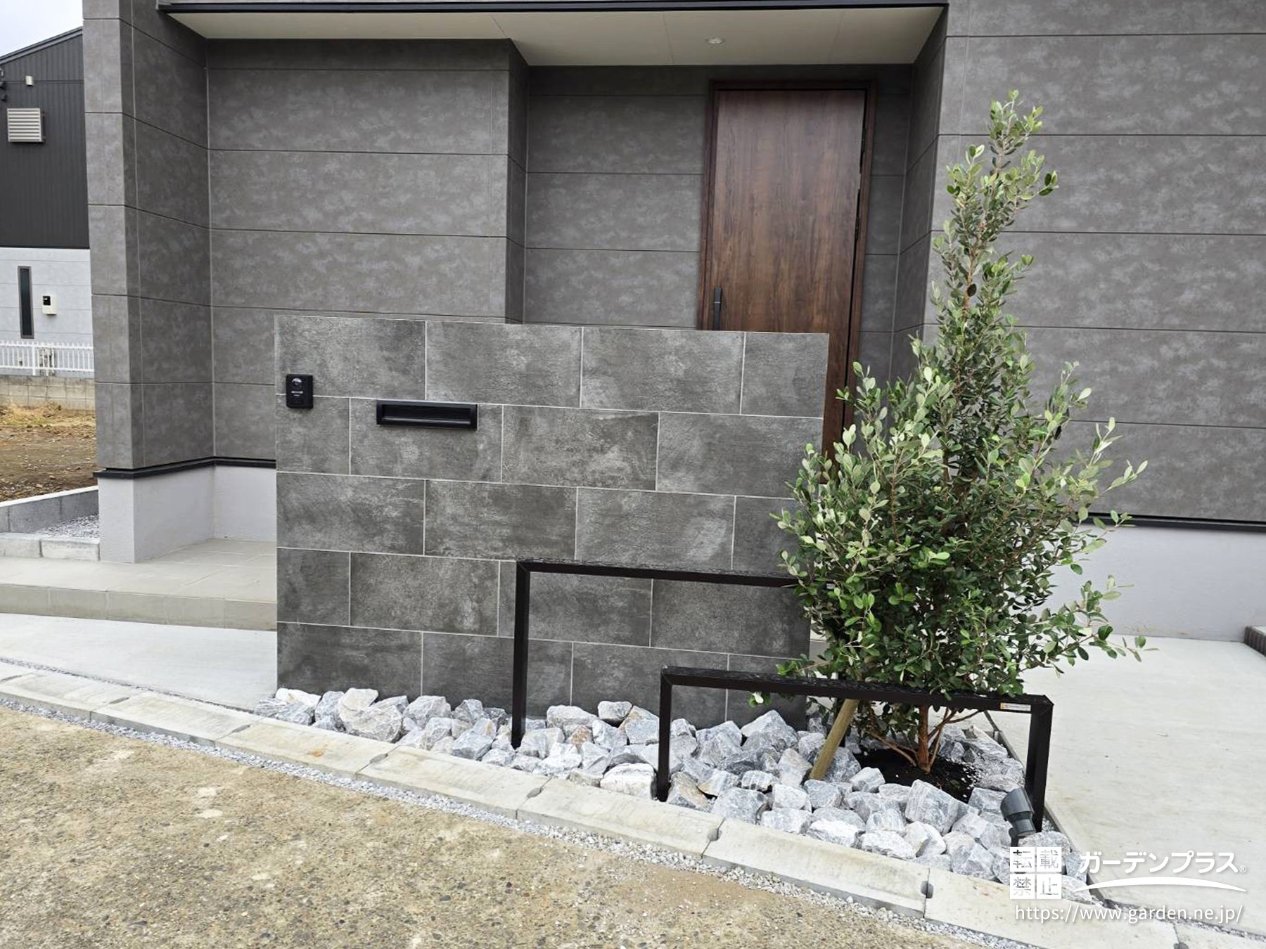 道路に面した家の玄関周りを目隠しするモダンなタイル門柱