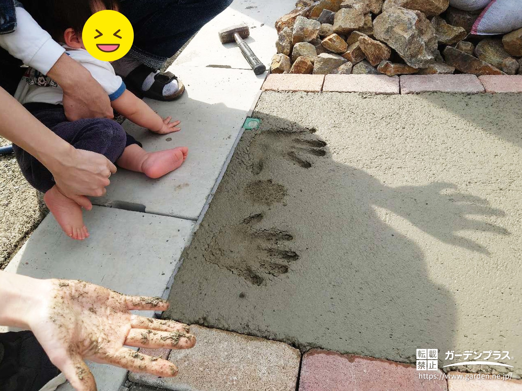 コンクリート打設時に家族で手形スタンプを入れている様子