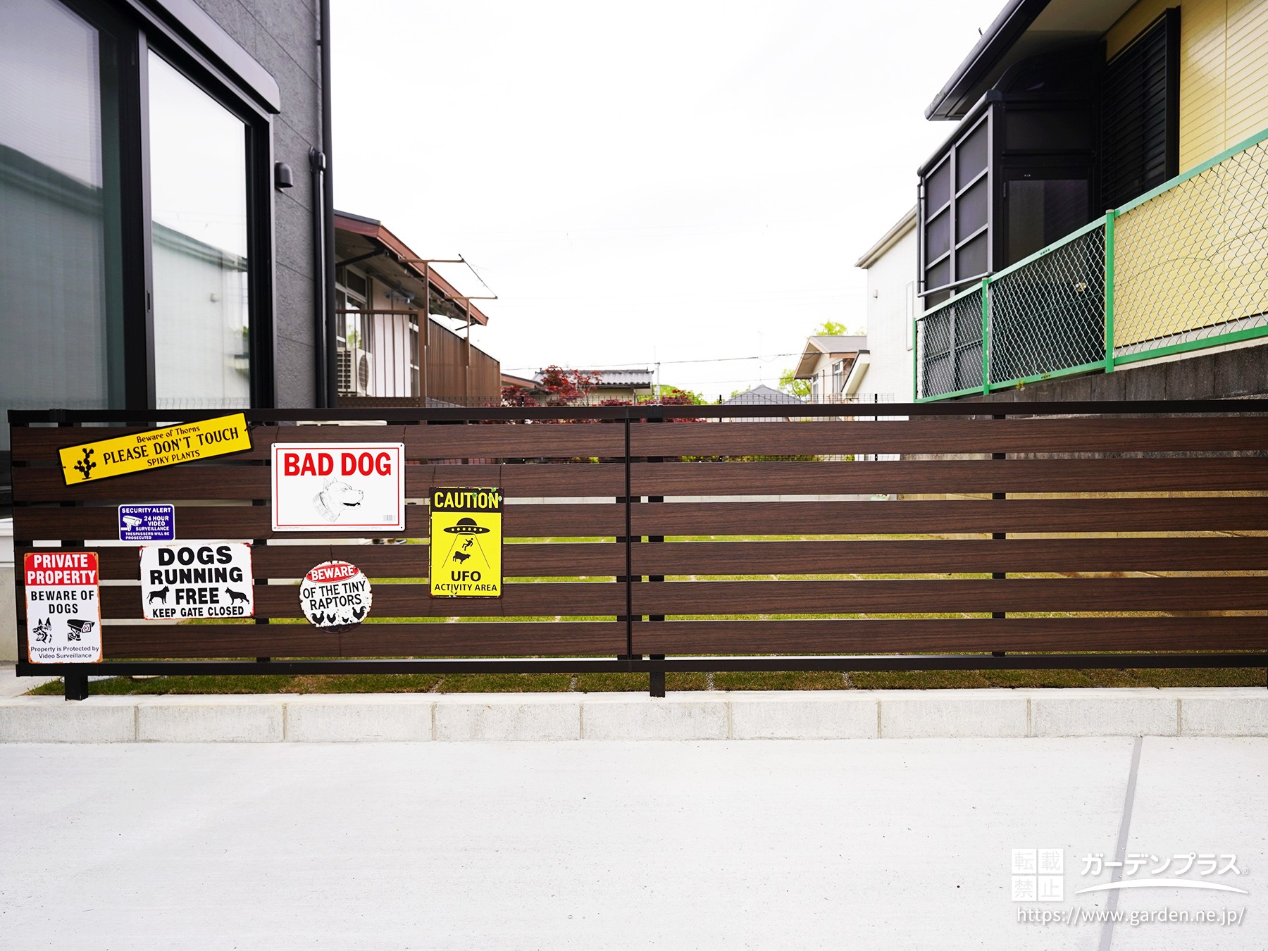おしゃれな看板を取り付けた木目調の目隠しフェンス