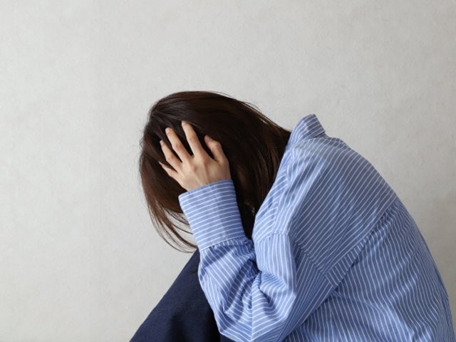 頭を抱えて後悔する女性