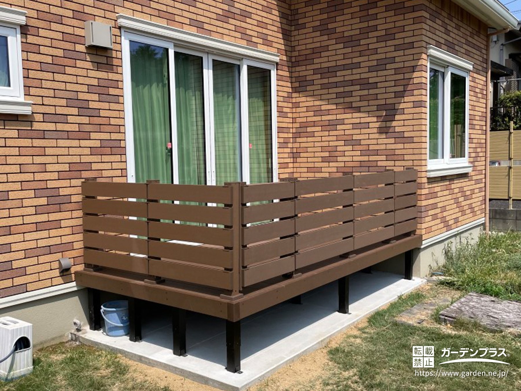 濃い茶色のウッドデッキとフェンス