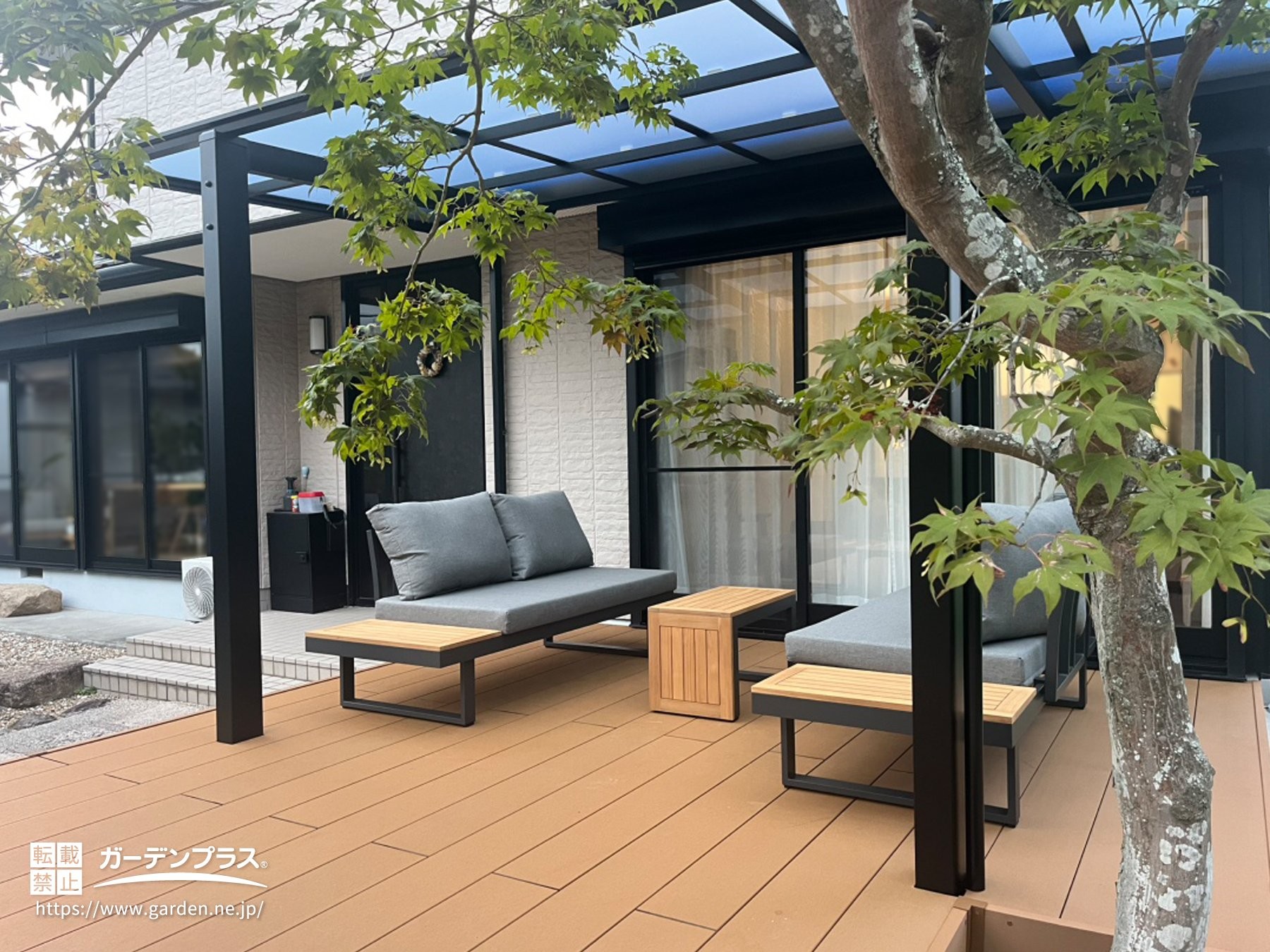 屋根付きの広々としたデッキにソファを置いたテラス