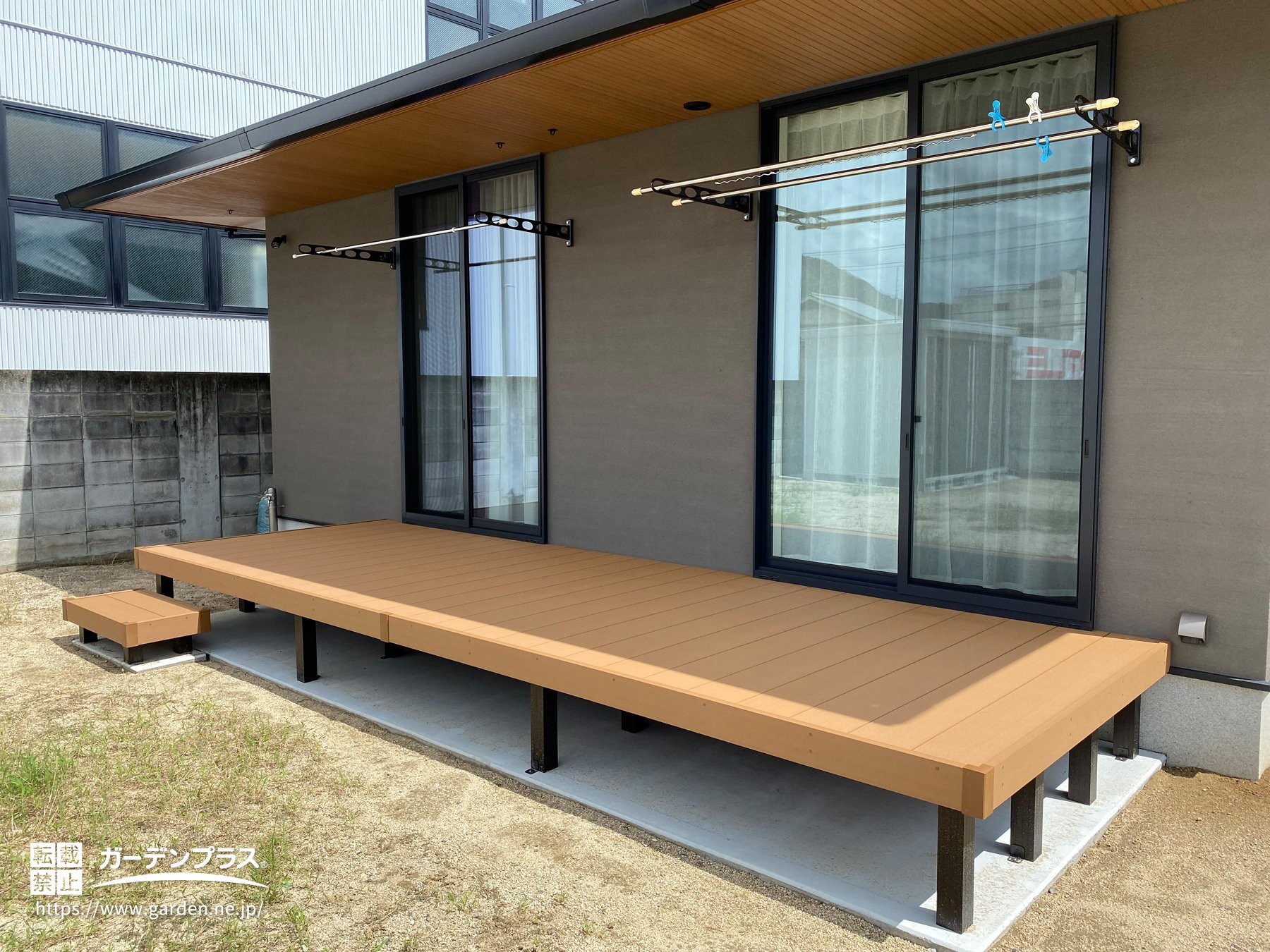 壁付け物干しのある掃き出し窓直結のデッキ