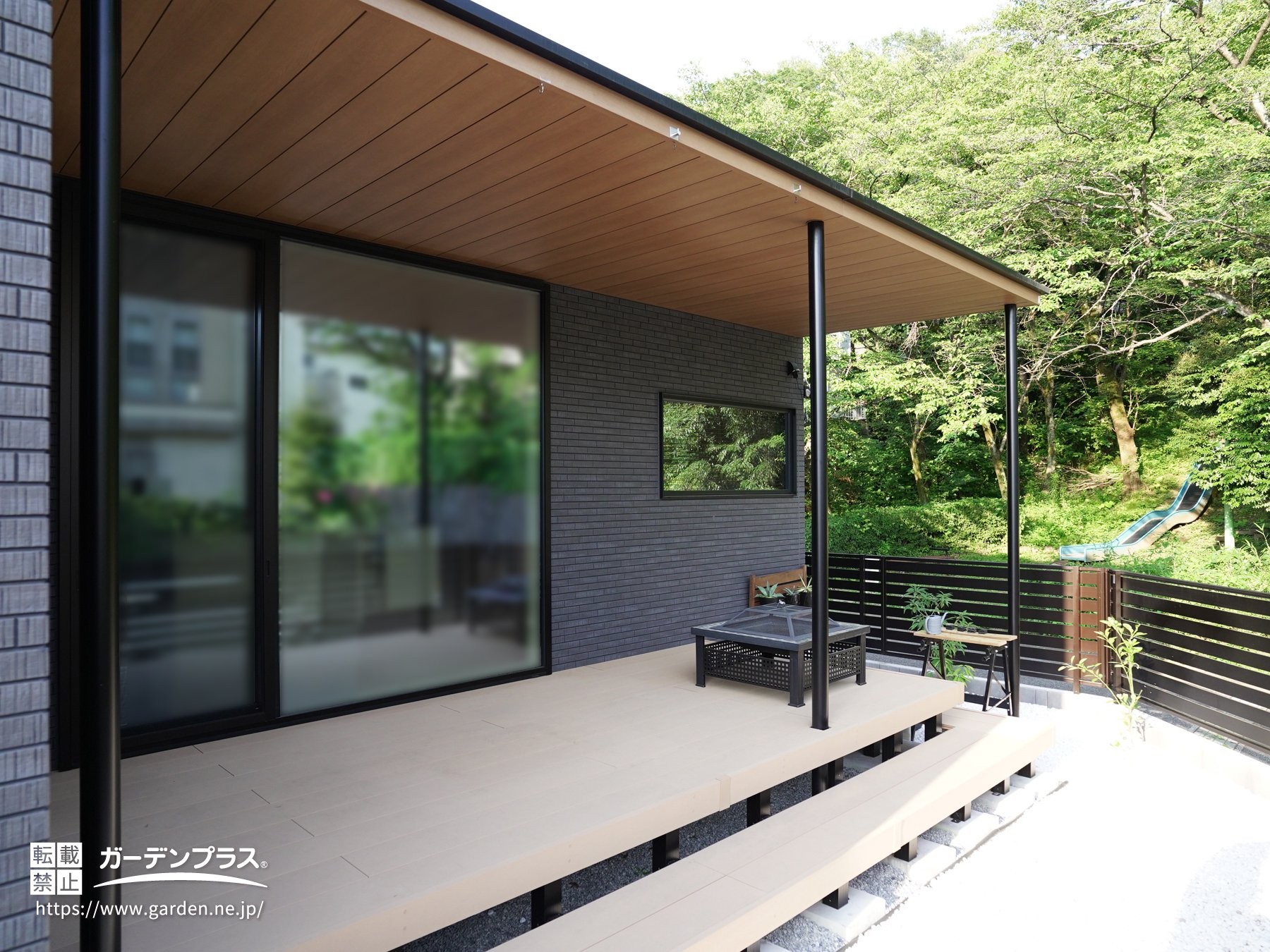 軒と一体化したような木調テラス屋根のウッドデッキ