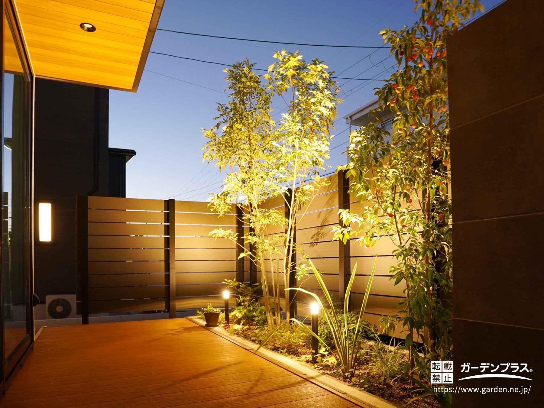 柔らかな光に照らされた夜の植栽とウッドデッキ