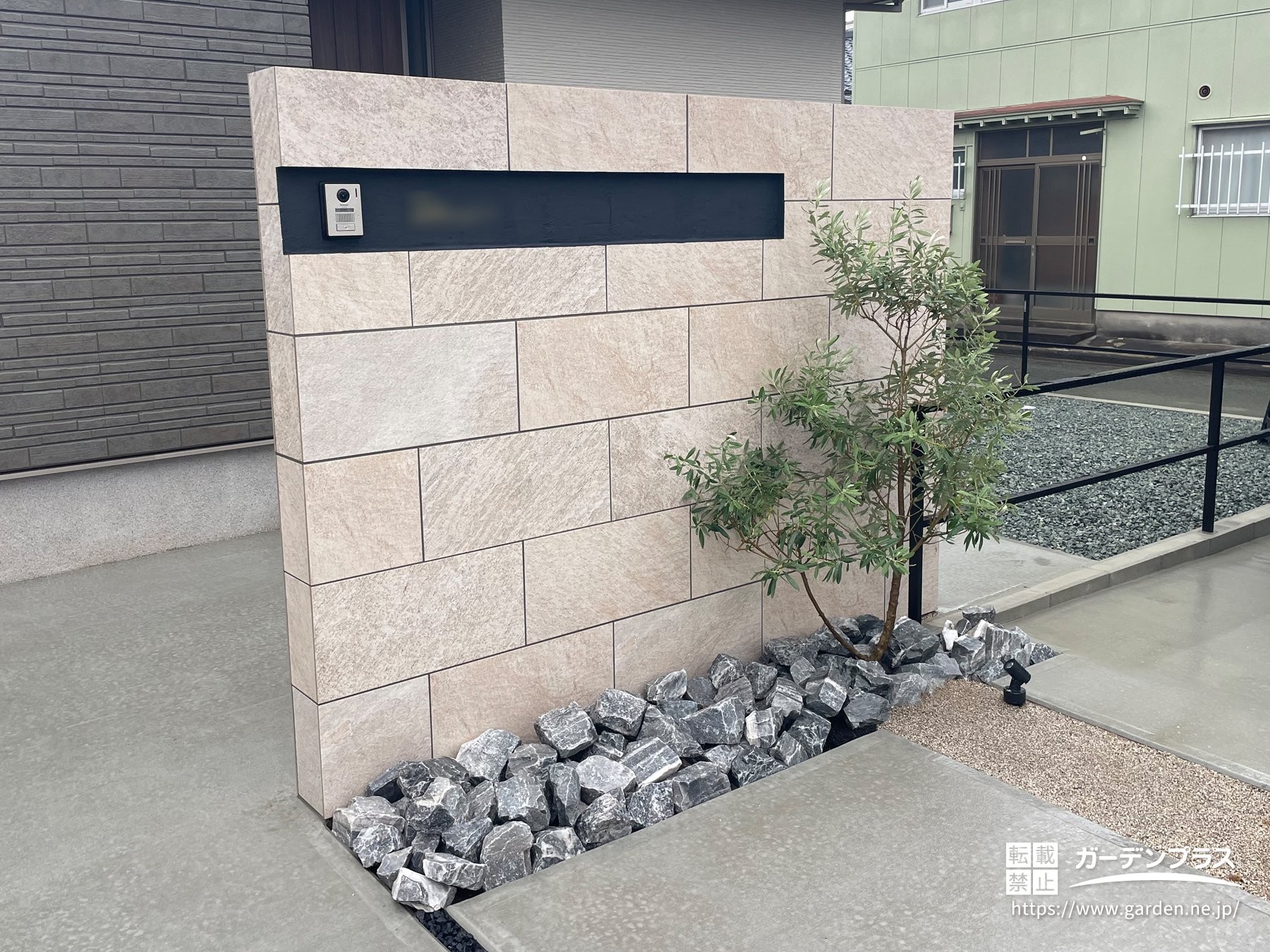 大判タイルで仕上げた門柱と植栽