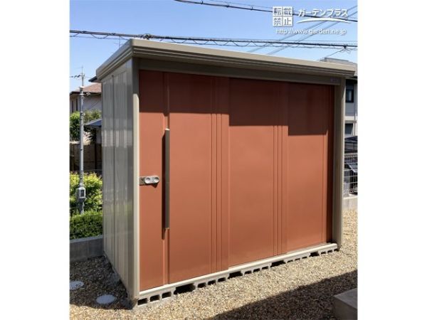 お庭の一画に大きな物置を設置。3枚扉なので開口部が広く、サイズの大きなものを簡単に収納できます。