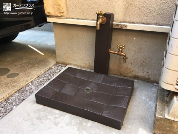 古木を再現したコンクリート製の立水栓にゴールドの蛇口を2つ取り付けホースを常時接続できるように。