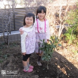 植樹したミカンの木と記念撮影