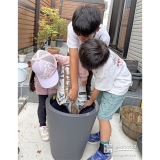 記念樹を植える植木鉢に土を入れる様子