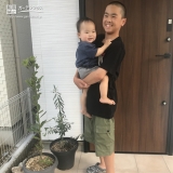 お父さんとお子さんのオリーブと月桂樹の植樹後の記念写真