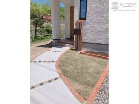 縁取りのレンガと芝生がナチュラルな雰囲気のアプローチ[施工後]