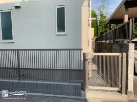 統一感のある縦格子フェンスと通用門