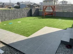 人工芝でのびのび遊べる前庭とタイル貼りのアプローチ[施工後]