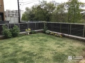 芝生の緑を引き立てる木目調フェンス[施工後]