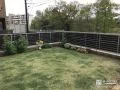芝生の緑を引き立てる木目調フェンス
