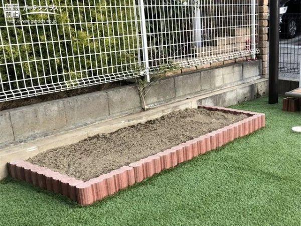 人工芝のお庭に馴染む温かみのある花壇