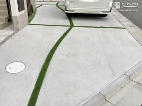 人工芝を敷いた曲線ラインの目地が優しい印象の駐車スペース[施工後]
