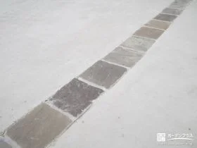 曲線が目立つよう伸縮目地とは別に取り入れたピンコロ石の目地。グレーカラーで滑らかな質感の石材を使用しました。