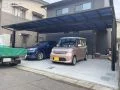 ファサードを覆う大きなカーポートが出迎える新築外構
