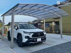 オレンジの目地やアール屋根のカーポートが優しい雰囲気の駐車スペース[施工後]