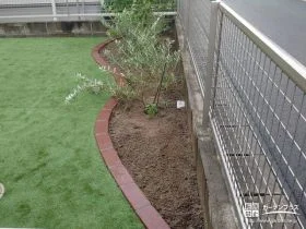 滑らかな曲線がナチュラルな印象の植栽スペース[施工後]