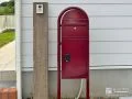 白を基調としたお住まいのポイントになる赤い宅配ポスト