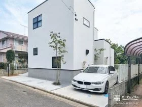 外壁の白に植栽の緑が映える爽やかな外構