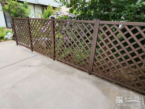 植栽の緑に映えるパインカラーの格子状目隠しフェンス設置工事