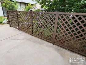 植栽の緑に映えるパインカラーの格子状目隠しフェンス設置工事