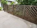 植栽の緑に映えるパインカラーの格子状目隠しフェンス設置工事