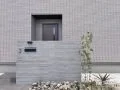 杉板調のタイルがモダンで洗練された印象を演出する門柱