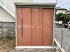 オレンジがフレッシュな物置きと敷地境界を明確化するフェンス[施工後]