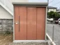 オレンジがフレッシュな物置きと敷地境界を明確化するフェンス