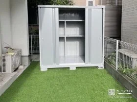 シンプルデザインの物置を人工芝の緑鮮やかなお庭に施工した工事