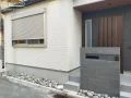 落ち着きのある天然石調タイルをあしらった門柱