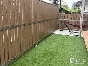 木目調フェンスが柔らかく目隠しをする人工芝の緑豊かなお庭工事