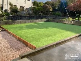 緑の人工芝とピンクの砂利のコントラストが美しいお庭工事