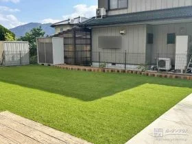 人工芝のお庭にレンガの花壇が温かみを添えたリフォーム工事
