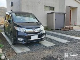 太い砕石スリットでボーダーのようなデザインに仕上げた駐車スペース[施工後]