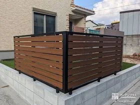 お庭の一画に木目調のフェンスを取り付け自然に目隠しをした工事
