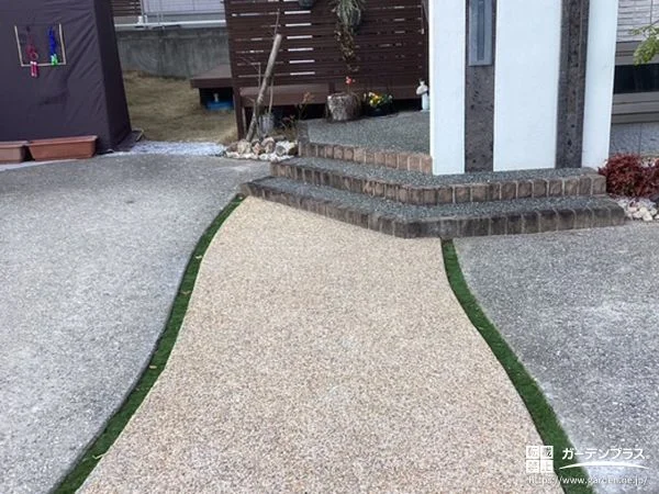 両脇に入れた人工芝の目地が可愛らしく映える玄関アプローチ工事