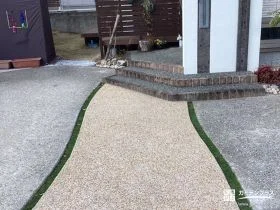 両脇に入れた人工芝の目地が可愛らしく映える玄関アプローチ工事