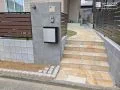 曲線ラインが柔らかく視線を導きく玄関アプローチ