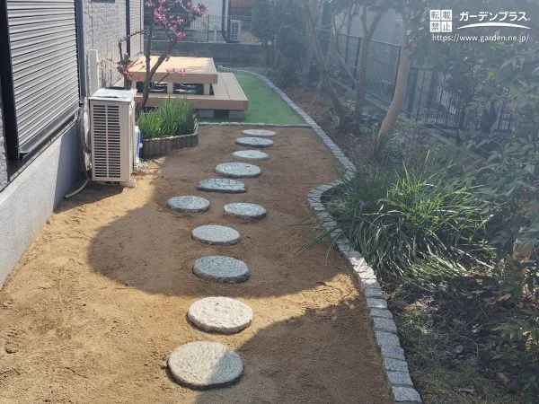 曲線がやさしく導く　ナチュラルな印象のピンコロ石花壇