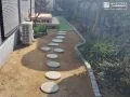 曲線がやさしく導く　ナチュラルな印象のピンコロ石花壇