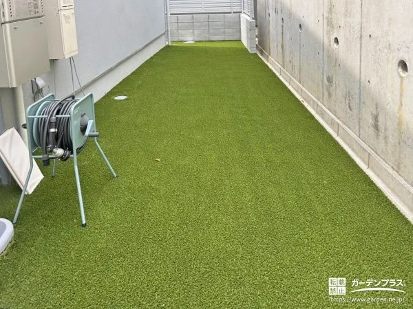 既存の防草シートとの上に人工芝を敷き緑をプラスしたお庭工事