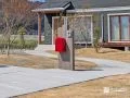 赤いポストが引き立つ、木調門柱のナチュラルコーデ