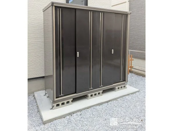 お庭の一画にシックなブラウンカラーの物置を設置